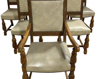 7777 - 6 Carved Oak Armchairs w/ Nailhead Trim (Description): Set of six carved oak armchairs featuring  turned and reeded legs, scrolled arms, and  decorative grape and vine motif carving on  the frame. The chairs are upholstered in a  neutral leather-look material with brass nail head trim on both the seat and back.  H-stretcher base provides stability. Jacobean  or Renaissance Revival style. Measures 41" x  23" x 20".