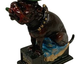 1515 - "Ole Puffer" Cast Iron Bulldog Bank 9"x7"x3" (Description): "Ole Puffer" cast iron bulldog bank featuring  a seated bulldog figure wearing a green  bowler hat and smoking a green cigar. The  bulldog has a brown painted body with  expressive features and sits atop a dark green pedestal base with "Ole Puffer" ribbed  in gold lettering. Measures 9" x 7" x 3".