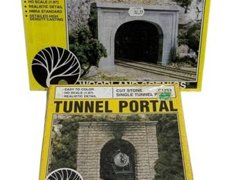 1060 - Pr Woodland Scenics Tunnel Portals (Description): A pair of Woodland Scenics tunnel portals for  model railroad layouts. The lot includes two  different portal styles in their original  packaging.