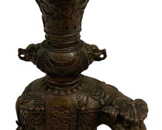 1535 - Bronze Elephant Vase 11"x8"x5" (Description): Bronze elephant vase featuring an ornately  decorated elephant figure with elaborate  ceremonial trappings and detailed relief  work. The elephant serves as the base,  supporting a flared gu-form vase with Greek key rim pattern, scrolling floral motifs,and  twin dragon-head handles. The piece displays  intricate beaded borders, lotus medallions,  and traditional Asian decorative elements  throughout. Measures 11 inches by 8 inches by
