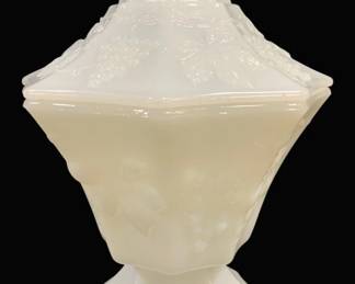 2006 - White Milk Glass Lidded Compote Grape Pattern (Description): White milk glass lidded compote featuring a  decorative grape and vine pattern in relief.  The piece has a paneled octagonal shape with  a pedestal base and fitted lid topped with a  faceted knob finial. Measures 8 inches by 6 inches.