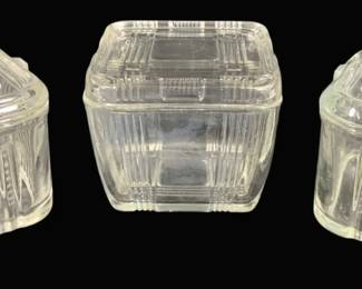 2005 - 3 Vintage Glass Refrigerator Dishes w/ Lids (Description): Set of three vintage clear pressed glass  refrigerator dishes with matching lids. The  collection includes two dishes with  decorative vegetable motifs on their lids and  one with a geometric ribbed pattern. Each container features ribbed sides and fitted  glass covers. Measures 3.5" x 4.5".