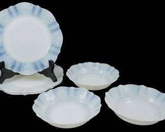 932 - 6 Monax American Sweetheart Dinnerware Items (Description): A collection of six Monax American Sweetheart  pattern pieces. This Depression-era  glassware grouping includes plates and bowls  featuring the distinctive scalloped edges and  delicate floral border design characteristic of the American Sweetheart pattern. The  pieces display the signature opalescent white  Monax glass with subtle blue-tinted edges.