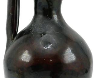 1002 - Vtg Black & Brown Pottery Rebecca Pitcher (Description): Vintage black and brown pottery Rebecca  pitcher featuring a distinctive tall looped  handle that rises above the pinched spout.  The vessel has a bulbous body with a footed  base and displays a rich, dark glaze with subtle color variations throughout. Measures  9 inches tall.