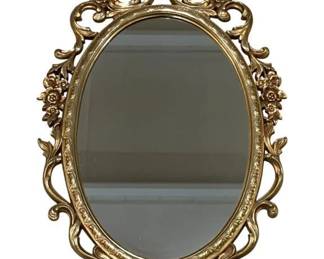 7725 - Vtg Gold Rococo Style Oval Wall Mirror 36x23 (Description): Vintage gold-toned oval wall mirror in the  Rococo style. The ornate frame features  scrollwork, floral accents, and a decorative  crest at top and bottom. Measures 36 inches  by 23 inches.