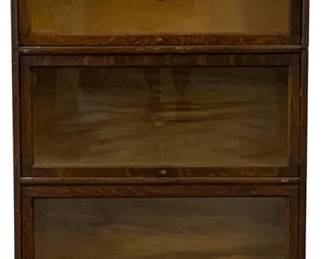 7502 - Weis Oak Barrister 3 Stack Bookcase (Description): Original Finish three level stackable  barrister bookcase in quartersawn oak with a  warm medium finish. Features three sections  with lift-up glass doors and brass knobs. The  bookcase stands on tapered square legs and showcases the distinctive tiger oak grain  pattern throughout. Measures 57 inches high  by 34 inches wide by 12 inches deep.