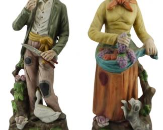 630 - Pair Vintage HOMCO Figurines 13" (Description): A pair of vintage HOMCO porcelain figurines  depicting an elderly peasant couple. The man  wears a hat and carries a tool, standing  alongside a goose. The woman wears a  headscarf and carries a basket of fruit, accompanied by a small dog. Each figure  measures 13 inches tall.