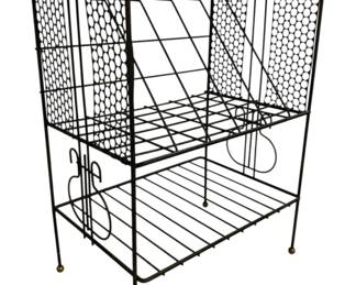 7598 - Vtg Black Metal Wire Record Holder Stand (Description): Vintage black metal wire record holder stand  featuring a mid-century modern design. The  stand has an open wire frame construction  with a tilted upper rack for displaying  records, a lower shelf for additional storage, and decorative mesh side panels.  Stands on four legs with brass ball feet.  Measures 28 inches high by 20 inches wide by  13 inches deep.