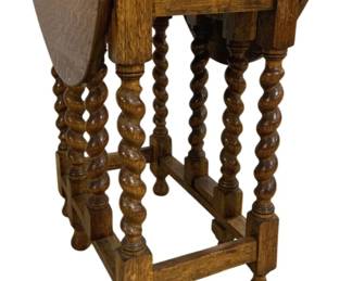 7739 - Oak Drop Leaf End Table w/ Barley Twist Legs (Description): Oak drop leaf end table featuring distinctive  barley twist legs and ball feet. The table  is constructed in a traditional English style  with gate-leg supports that swing out to  hold the drop leaves when extended. The warm honey-toned oak displays attractive wood  grain throughout. Measures 29" x 35" x 25".