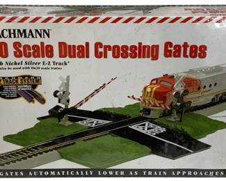 1644 - Bachmann HO Scale Dual Crossing Gates (Description): Bachmann HO Scale Dual Crossing Gates with  Nickel Silver E-Z Track. This model railroad  accessory features automatic crossing gates  that lower as the train approaches.  Compatible with HO scale and can also be used with On30 scale trains. Part of the Bachmann  E-Z Track System. Factory sealed in original  packaging.