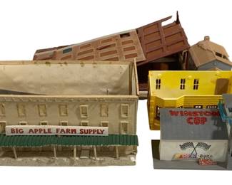 1709 - Lot of HO Scale Model Railroad Buildings (Description): A lot of HO scale model railroad buildings  suitable for train layouts. The collection  includes several structures featuring a Big  Apple Farm Supply store, a NASCAR Winston Cup  racing facility with grandstand and tower, a yellow commercial building,a gray  Victorian-style house, and additional brown  warehouse or barn structures. Buildings show  typical wear consistent with use in model  railroad displays.