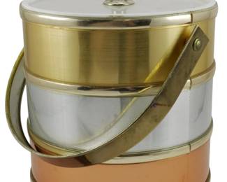 859 - Mid Century Sheltonware For Towle Ice Bucket (Description): Mid Century Sheltonware ice bucket featuring  a striking tri-tone design with alternating  bands of brass, chrome, and copper. The  bucket has a polished chrome lid with a ring  finial and a brass bail handle. This stylish barware piece exemplifies mid-century modern  design with its mixed metal aesthetic.  Measures 10 inches tall by 8 inches in  diameter.