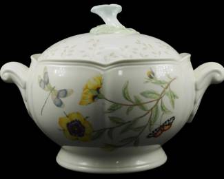 776 - Lenox Butterfly Meadow Tureen 8"x11"x8" (Description): Lenox Butterfly Meadow tureen with lid,  featuring the collection's signature  botanical motif with yellow flowers, green  foliage, butterflies, and dragonflies on a  cream-colored porcelain body. The tureen has elegant scrolled handles on each side and  rests on a pedestal foot. The domed lid is  decorated with delicate leaf sprays and  topped with a sculpted floral finial.  Measures 8"x11"x8".