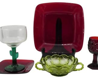 1013 - Assorted Colored Glass Tableware Collection (Description): A collection of assorted colored glass  tableware pieces including ruby red square  plates, a margarita glass with a green  cactus-shaped stem, an avocado green pressed  glass double-handled sugar bowl with a scalloped edge, and a ruby red Cape Cod style  cordial glass with grape and leaf pattern.  The pieces represent various mid-century  American glass styles.