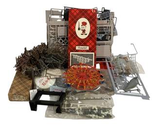 1713 - Lot HO Scale Model Railroad Accessories (Description): A lot of HO scale model railroad items  including various gray plastic bridge and  trestle components, track sections, a  multi-colored Ferris wheel structure,  platform pieces, and assorted small accessories. Some items remain in original  packaging. The lot includes a Campbell  branded box featuring their signature  character logo on a red diamond pattern  background.