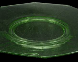 1243 - Vtg Decagon Uranium Depression Glass Platter (Description): Vintage Decagon uranium depression glass  platter featuring an elegant green vaseline  glass construction with distinctive octagonal  shape and decorative double-loop handles on  each end. The platter displays the characteristic translucent green coloring  typical of uranium glass from the Depression  era, with a circular center well and paneled  design radiating outward. Measures 11" x  12.5".
