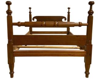 7701 - Antique Cannonball Four Poster Bed (Description): Full size antique cannonball four poster bed  crafted in warm cherry or maple wood. The bed  features distinctive turned cannonball  finials atop each of the four posts, with the  taller headboard posts creating an elegant silhouette. The headboard includes a shaped  crest rail with scrolled detailing and a  turned bolster rail below. The footboard  posts are shorter with matching cannonball  tops. The bed displays classic American