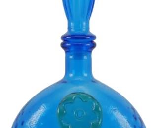855 - Vintage Empoli Blue Glass Genie Bottle 15" (Description): Vintage Empoli blue glass genie bottle  featuring a spherical body with an optic  ribbed pattern and applied teal flower  medallion on the front. The bottle is topped  with an elongated flame-shaped stopper in matching blue glass. Measures 15 inches tall.