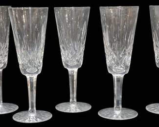 917 - 5 Waterford Crystal Lismore Champagne Flutes (Description): Set of four Waterford Crystal champagne  flutes in the classic Lismore pattern. Each  flute features the signature diamond and  wedge cuts on the bowl with a multisided stem  rising from a starburst-cut circular foot. The flutes measure 7.5 inches tall.