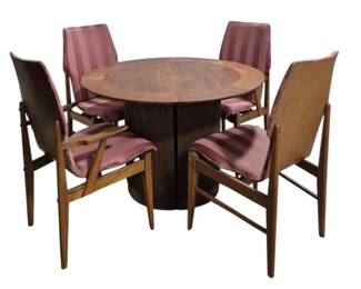 1422 - Lane First Edition Mid-Century Dinette Set (Description): Lane dinette set featuring a round pedestal  table with two leaves and four matching  chairs. The table has a beautiful burl wood  top with decorative banding and a dark fluted  pedestal base. Set includes two armchairs and two side chairs upholstered in mauve  striped fabric with warm-toned wood frames in  a mid-century modern style. Table measures  29.25 inches high by 44 inches round with two  17.5 inch leaves. Chairs measure 39 inches