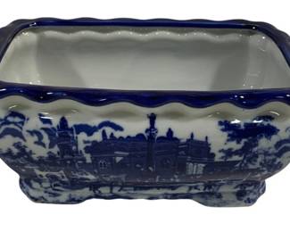 1528 - Blue & White Transferware Ceramic Tub (Description): Blue and white transferware ceramic tub  featuring a scenic landscape design with  architectural elements including buildings  and monuments. The rectangular vessel has a  scalloped cobalt blue rim edge and decorative handles on each end. The interior is  finished in white. Measures 12 inches long by  6.5 inches wide by 5 inches tall.