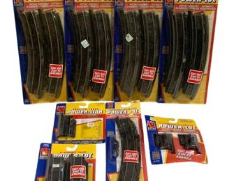 1669 - 6pc Lot Life-Like Trains HO Scale Track (Description): Six-piece lot of Life-Like Trains HO scale  Power-Loc track sections. The lot includes  four packages of curved track sections and  additional packages containing straight  track, adapter track (Power-Link), and terminal/rerailer pieces. All pieces remain  in their original unopened packaging  featuring the distinctive red, blue, and  yellow Life-Like Trains branding with 'Fast  and Easy to Assemble' labeling.