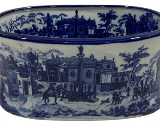 1545 - Blue & White Transferware Footbath Tub (Description): Blue and white transferware footbath tub  featuring scenic decoration with  architectural landscapes, figures on  horseback, and village scenes. The oval tub  has two handles with cobalt blue accents and a matching cobalt blue rim. Measures 14  inches by 9 inches by 6 inches.