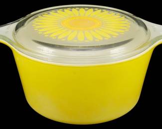 1153 - Pyrex Sunflower 1 Quart Casserole w/ Lid (Description): Pyrex Sunflower pattern 1 quart casserole  dish with matching clear glass lid. The dish  features the classic yellow exterior with the  distinctive daisy sunflower design on the  lid in yellow and orange tones. This vintage piece from Pyrex's popular Sunflower line  includes the original fitted lid with tab  handles. Measures 3.5 inches tall by 6 inches  wide by 8 inches across including handles.