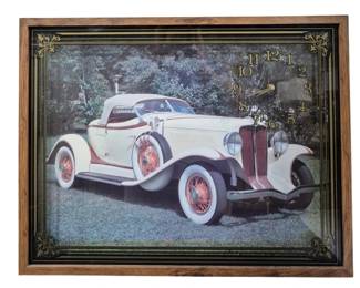 1430 - Wall Clock w/ Car Image (Description): 21 x 27 - Wall clock featuring a car image.  The clock is framed and designed as a  decorative wall piece combining timepiece  functionality with automotive artwork. Used  as is electric/electronic/mechanical item. No guarantee all components present, untested.