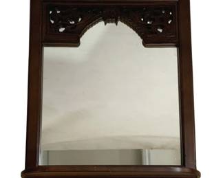 7730 - Carved Mahogany Wall Mirror w/ Shelf 28"x23" (Description): A handsome wall mirror featuring a carved  mahogany frame with decorative pierced  scrollwork at the top creating an arched  accent. The frame has a rich dark finish and  includes a small shelf at the base. Measures 28 inches by 23 inches.