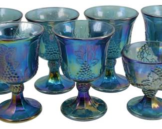 716 - Vtg Indiana Blue Harvest Carnival Glass Stems (Description): Vintage Indiana Blue Harvest Carnival Glass  set of seven stems in two sizes. The  iridescent blue glass features the classic  grape and leaf pattern with a footed pedestal  design. Measures 4 and 5.5 inches tall.