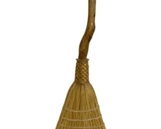 7649 - Handcrafted Straw Broom w/ Branch Handle (Description): Rustic handcrafted straw broom featuring a  natural twisted branch handle. The broom head  is made of traditional straw with woven  binding at the neck. Measures 36 inches in  length. A charming folk art or decorative piece with a distinctive organic handle.