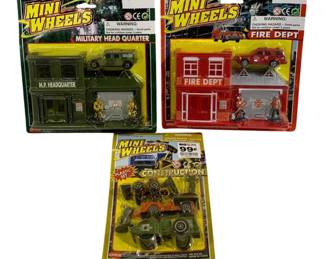 1635 - Mini Wheels Vtg Playset Lot Military Fire Toy (Description): Three-piece lot of vintage Mini Wheels toy  playsets by Supreme. The collection includes  a Military Head Quarter set featuring an M.P.  Headquarter building with military vehicle  and soldier figures, a Fire Dept set with fire station building, fire truck, and  firefighter figures, and a Construction  plastic set with construction vehicles and  equipment. All sets remain in their original  sealed packaging.