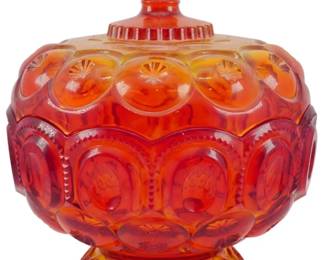 1007 - L.E. Smith Amberina Moon & Star Covered Dish (Description): Vintage L.E. Smith Amberina Moon & Star  covered dish. This striking pressed glass  piece features the iconic Moon & Star pattern  with rich amberina coloring that transitions  from deep ruby red to golden amber. The footed compote-style dish has a decorative  lid topped with a crown-shaped finial.  Measures 10" x 8".