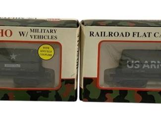 1577 - Model Power U.S. Army Tank Cars HO Scale (Description): Two Model Power U.S. Army tank cars in HO  scale. Each boxed set features a railroad  flat car with military vehicles. The olive  drab US Army tank cars are presented in their  original packaging with camouflage-themed boxes. Both sets include knuckle couplers as  noted on the packaging.