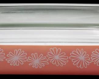 1107 - Vtg Pyrex Pink Daisy Casserole Dish w/ Lid (Description): Vintage Pyrex pink tray dish with lid  featuring a charming white daisy pattern  around the exterior. This mid-century  casserole dish has a distinctive pink body  decorated with stylized white floral motifs and comes complete with its original clear  glass lid. Measures 4" x 11" x 7".