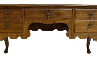 7748 - English Queen Anne Desk 30"x53"x25" (Description): English Queen Anne style desk featuring rich  walnut wood construction with beautiful grain  patterns. The desk includes five drawers  with decorative brass drop bail hardware and  escutcheons. The piece showcases classic Queen Anne design elements including graceful  cabriole legs and a scalloped apron with a  central arched opening. Measures 30 inches  high by 53 inches wide by 25 inches deep.