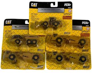 1036 - 5 Norscot 1/87 CAT Vehicles (Description): A collection of five Norscot 1/87 scale CAT  construction vehicles. These die-cast models  feature authentic Caterpillar branding and  details. All pieces remain in original  packaging.