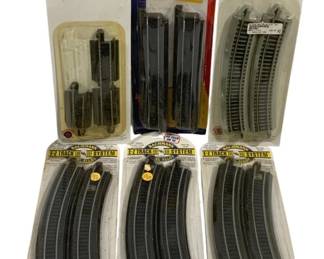 1614 - 6pc Lot HO Scale Train Tracks (Description): Six-piece lot of HO scale train tracks. The  lot includes Bachmann E-Z Track System pieces  in both steel alloy and nickel silver  varieties, featuring straight and curved  track sections. Also includes a Life-Like Power-Loc straight track pack. All pieces  remain in original retail packaging.