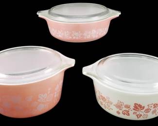 1204 - Pyrex Gooseberry 3pc Casserole Set w/ Lids (Description): Vintage Pyrex Gooseberry three-piece  casserole set. The collection includes two  pink casserole dishes and one white casserole  dish, all featuring the classic Gooseberry  pattern with delicate floral and berry motifs. Each piece comes with its original  clear glass lid. A charming addition to any  mid-century kitchen collection.