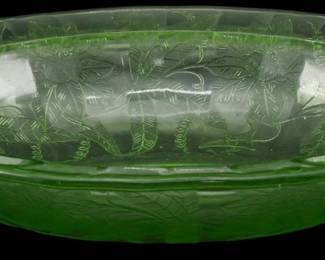 1241 - Vtg Floral Uranium Depression Glass Bowl (Description): Vintage floral uranium depression glass bowl  featuring an elegant pressed leaf and floral  pattern throughout. The translucent green  vaseline glass displays the characteristic  glow associated with uranium glass from this era. The oval-shaped bowl hasa gently  scalloped edge and shallow profile. Measures  2 inches tall by 9 inches long by 7 inches  wide.