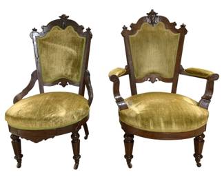 7640 - Pair Victorian Carved Walnut Parlor Chairs (Description): Pair of Victorian parlor chairs featuring  carved walnut frames with ornate crest rails  and scrolled arms. The chairs are upholstered  in chartreuse velvet on the seats, backs,  and armrests. Each chair rests on turned front legs with casters. Measurements:  41"x26"x23" and 43"x24"x28".