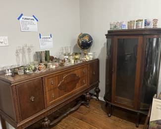 Antique curio cabinet and antique sideboard, candle holders, and gemstone globe