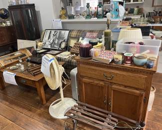Wall hangings and clocks, vintage sled, candles, coffee table, side table, and couch