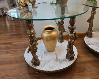 vintage Hollywood Regency style glass end table featuring ornate, gilded cherub or putti figures