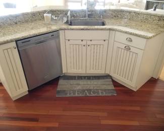 Kitchen island features KitchenAid dishwasher with stainless steel interior