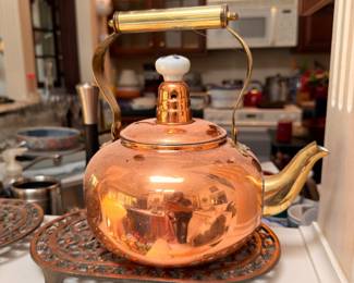 Copper tea kettle on cast iron trivet