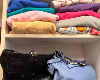 Folded sweaters and leather handbags