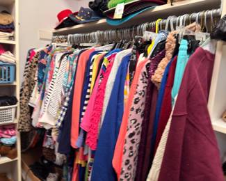 Closet of women's clothing with hats and baskets