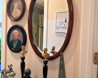 Oval wall mirror, bronze busts and obelisk